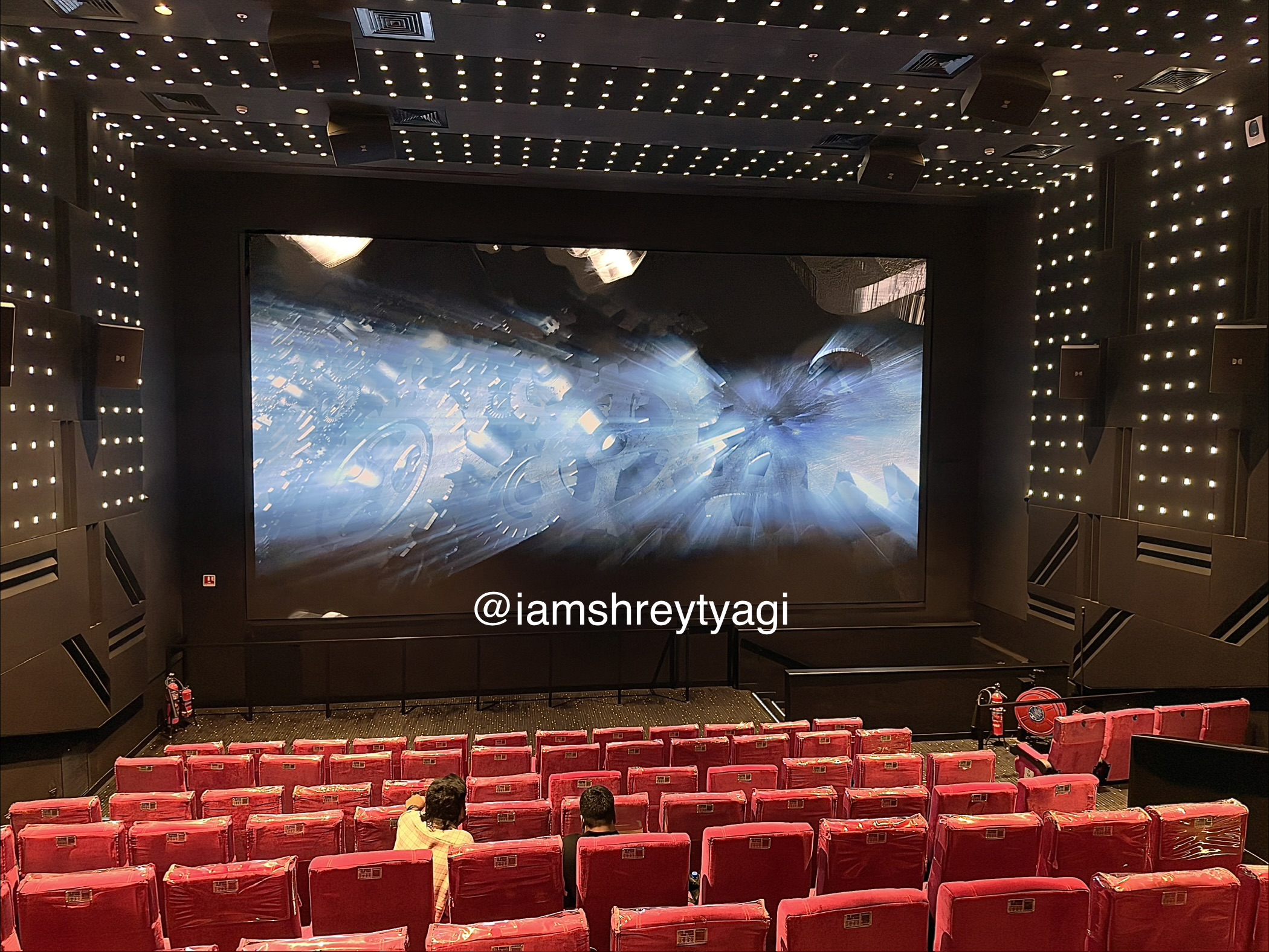 Wide shot of screen and auditorium from the back
