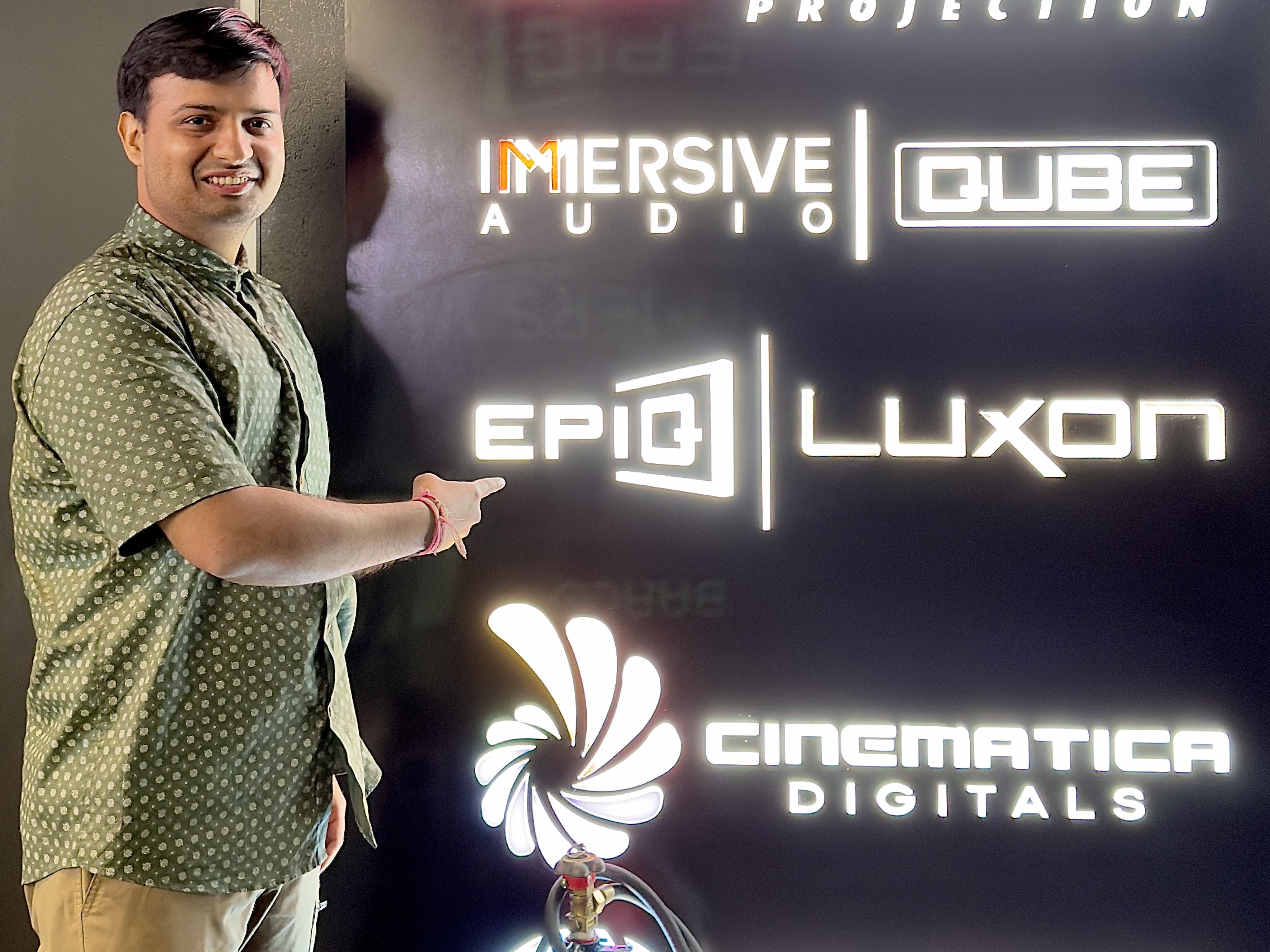 Me standing at entry pointing towards EPIQ LUXON logo